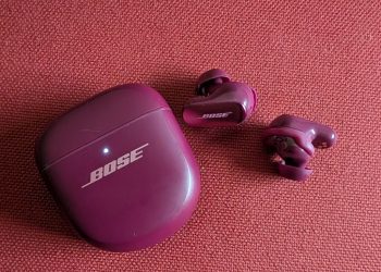 Auriculares Bose QuietComfort Ultra 2 pretos numa mesa com estojo de carregamento sem fios