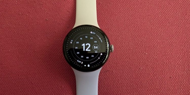 Relógio inteligente Google Pixel Watch 4 com mostrador circular e bracelete metálica sobre fundo neutro.
