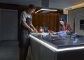 Luminárias e tiras de luz Philips Hue iluminam uma sala moderna com tons quentes e acolhedores.