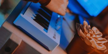 Controlador Arturia KeyStep 37 mk2 visto de cima, com 37 teclas, encoders adicionais e LEDs sobre o teclado, ligado a um setup de estúdio híbrido.
