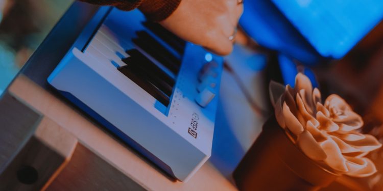 Controlador Arturia KeyStep 37 mk2 visto de cima, com 37 teclas, encoders adicionais e LEDs sobre o teclado, ligado a um setup de estúdio híbrido.