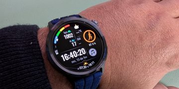 Huawei Watch GT Runner 2 em titânio no pulso de um corredor em corrida urbana com ecrã a mostrar ritmo e mapa GPS