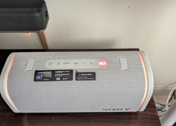 Sony ULT Field 5 coluna Bluetooth portátil em cor branca sobre superfície exterior com luz natural