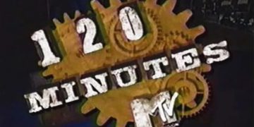 Ecrã de televisão antigo a exibir videoclip de música alternativa dos anos 90 estilo MTV 120 Minutes com VHS e cassetes em redor
