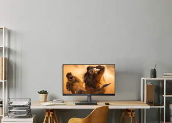 monitor gaming AGON by AOC G4 com ecrã curvo e iluminação ambiente num setup moderno