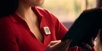 Button Computer wearable de inteligência artificial em alumínio escovado com design semelhante ao iPod Shuffle preso a uma camisa