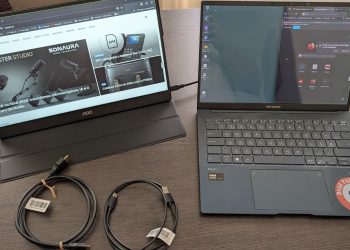 Monitor portátil AOC 16T20E2 de 15,6 polegadas em painel IPS ligado a um portátil por cabo USB-C numa secretária de trabalho remoto em ambiente de coworking