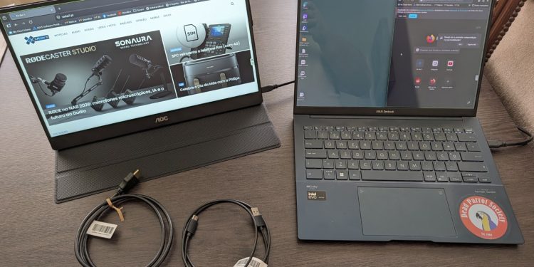 Monitor portátil AOC 16T20E2 de 15,6 polegadas em painel IPS ligado a um portátil por cabo USB-C numa secretária de trabalho remoto em ambiente de coworking