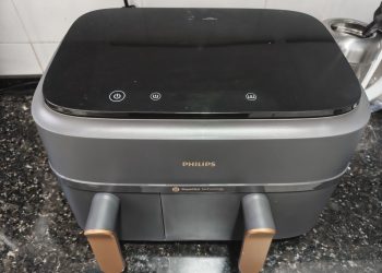 Philips Air Fryer Série 3000 Cesta Dupla NA352/00 em cinzento mate com detalhes metálicos dourados sobre bancada de cozinha moderna, com as duas gavetas abertas e o ecrã táctil iluminado