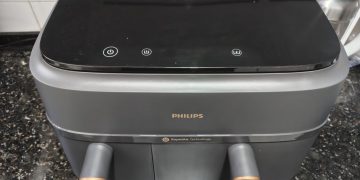 Philips Air Fryer Série 3000 Cesta Dupla NA352/00 em cinzento mate com detalhes metálicos dourados sobre bancada de cozinha moderna, com as duas gavetas abertas e o ecrã táctil iluminado