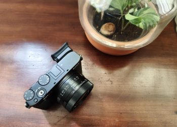 Sony RX1R III em magnesio preto mate sobre mesa de madeira, com a lente Zeiss Sonnar 35mm f/2 em destaque e o visor EVF fixo