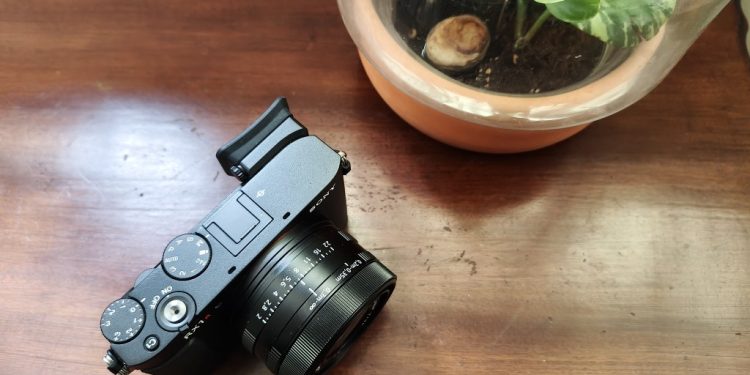 Análise Sony RX1R III, a compacta dos 5000€ 1 Sony RX1R III em magnesio preto mate sobre mesa de madeira, com a lente Zeiss Sonnar 35mm f/2 em destaque e o visor EVF fixo