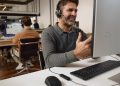 headset HP Poly Mission e barra Poly Studio V12 numa sala de reuniões moderna