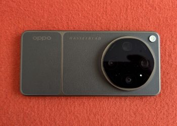 OPPO Find X9 Ultra em Tundra Umber sobre superfície de madeira, com o módulo de câmara circular Hasselblad em destaque e o botão de disparo laranja visível no lateral