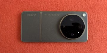 OPPO Find X9 Ultra em Tundra Umber sobre superfície de madeira, com o módulo de câmara circular Hasselblad em destaque e o botão de disparo laranja visível no lateral