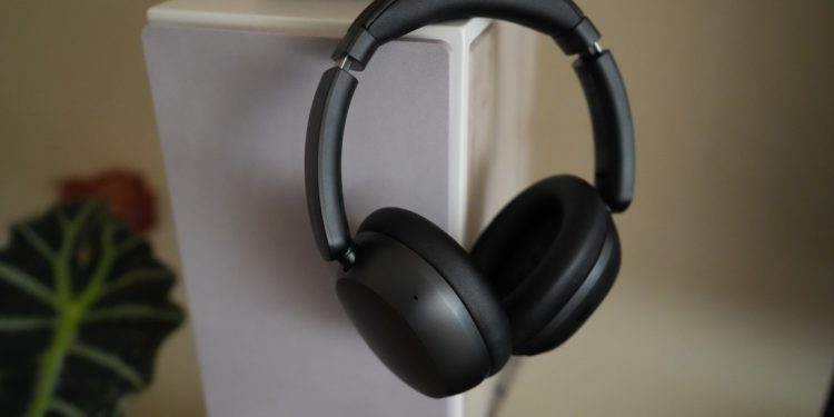 Redmi Headphones Neo em Obsidian Black sobre superfície branca, mostrando o design minimalista over-ear com auriculares acolchoados e banda de cabeça ajustável