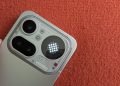 Nothing Phone 4a Pro em prata polido sobre superfície escura, com o módulo de câmara transparente e o Glyph Matrix circular activo a mostrar o relógio
