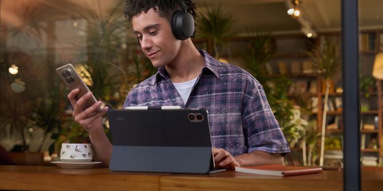 Xiaomi REDMI Headphones Neo em preto sobre uma mesa, destacando o design over-ear e a autonomia de 72 horas.