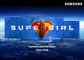 TV Samsung de grande formato exibe uma cena do filme Supergirl com cores vibrantes e elevado detalhe de imagem.