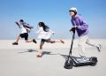 Trotinete eléctrica Segway Ninebot E3 em circulação numa avenida urbana, destacando a mobilidade urbana e o design moderno.