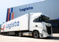 Contentores com smartphones e equipamentos tecnológicos num centro logístico europeu, ilustrando o comércio tecnológico da UE.