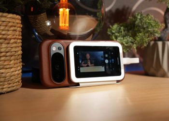 Insta360 Snap ligado magneticamente à traseira de um smartphone durante a gravação de uma selfie.