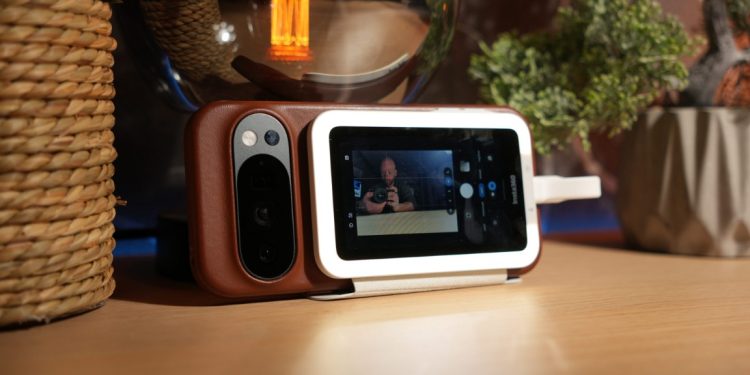 Insta360 Snap ligado magneticamente à traseira de um smartphone durante a gravação de uma selfie.
